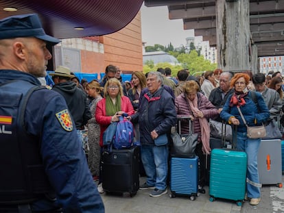 Viajeros esperando noticias de los trenes retrasados en la estación de Atocha, la mañana de este lunes.